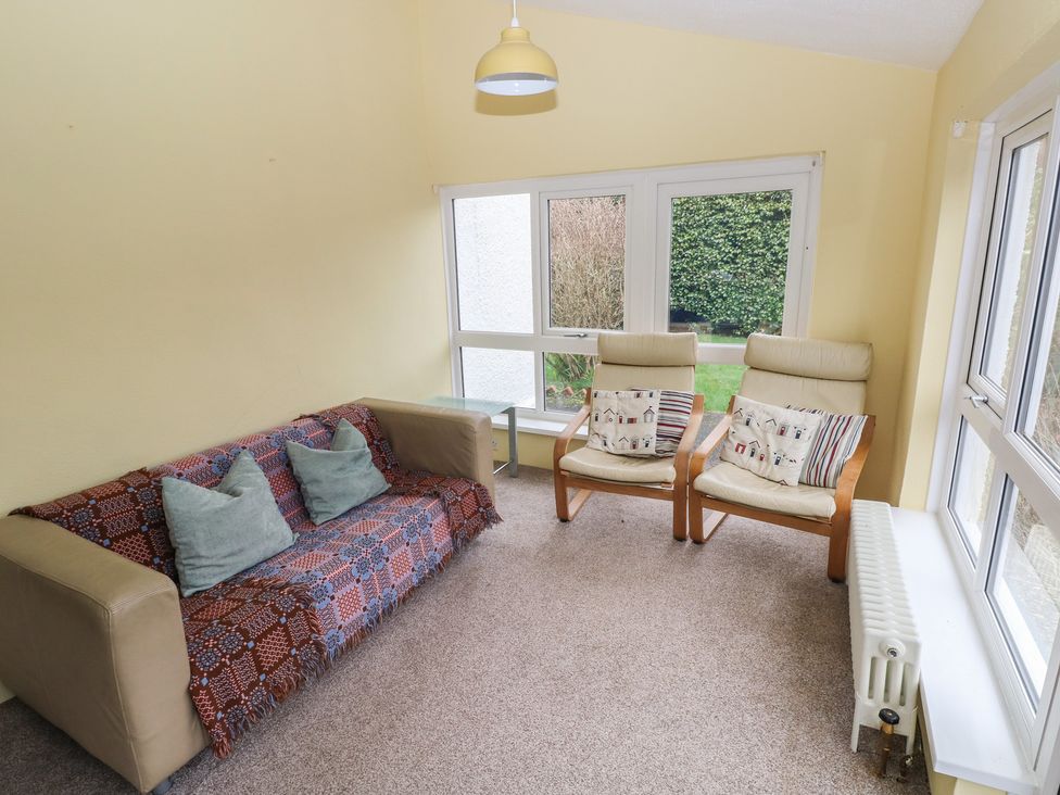 A sunroom with seating and a table at Kenvor in Newport, Pembrokeshire