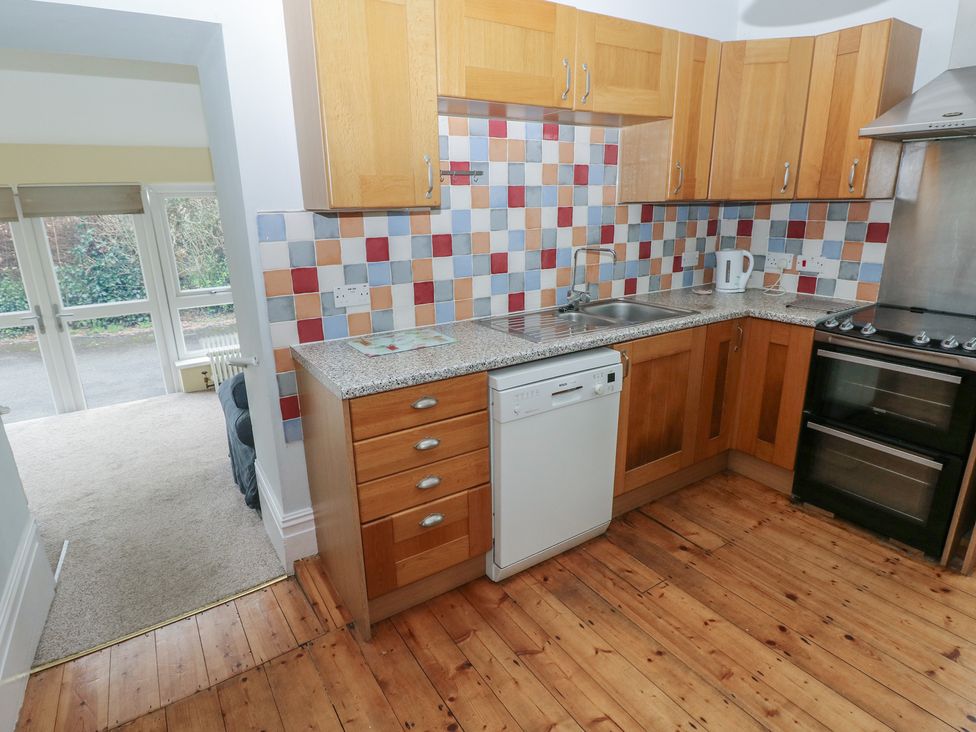 A kitchen with wooden cabinets and appliances at Kenvor in Newport, Pembrokeshire