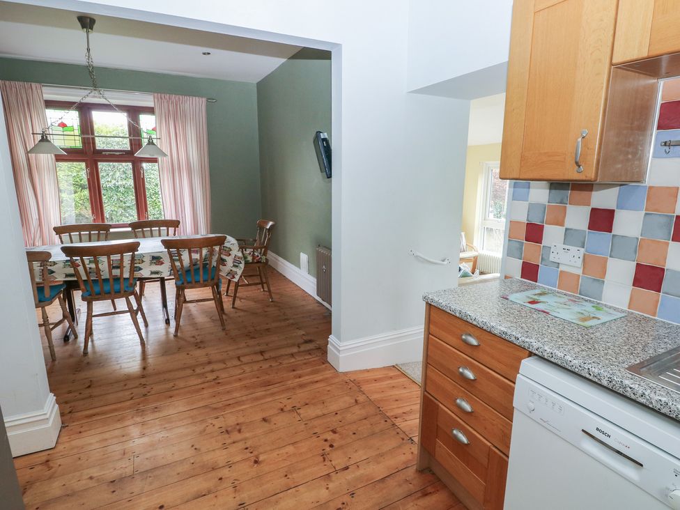 A kitchen with a dining area and wooden furniture at Kenvor, Newport, Pembrokeshire