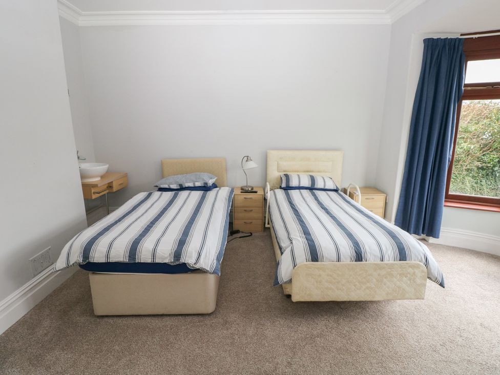 A bedroom with two single beds and a washbasin at Kenvor in Newport, Pembrokeshire