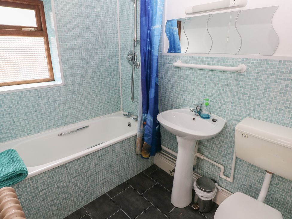 A bathroom with a bathtub and sink at Kenvor in Newport, Pembrokeshire