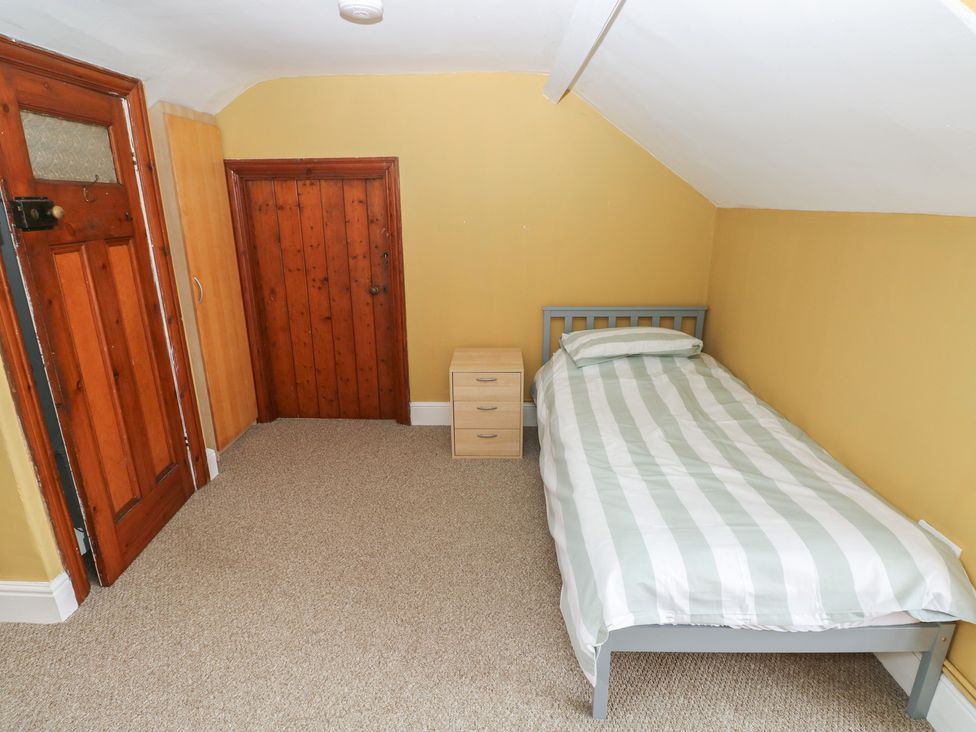 A bedroom with a bed and nightstand at Kenvor in Newport, Pembrokeshire