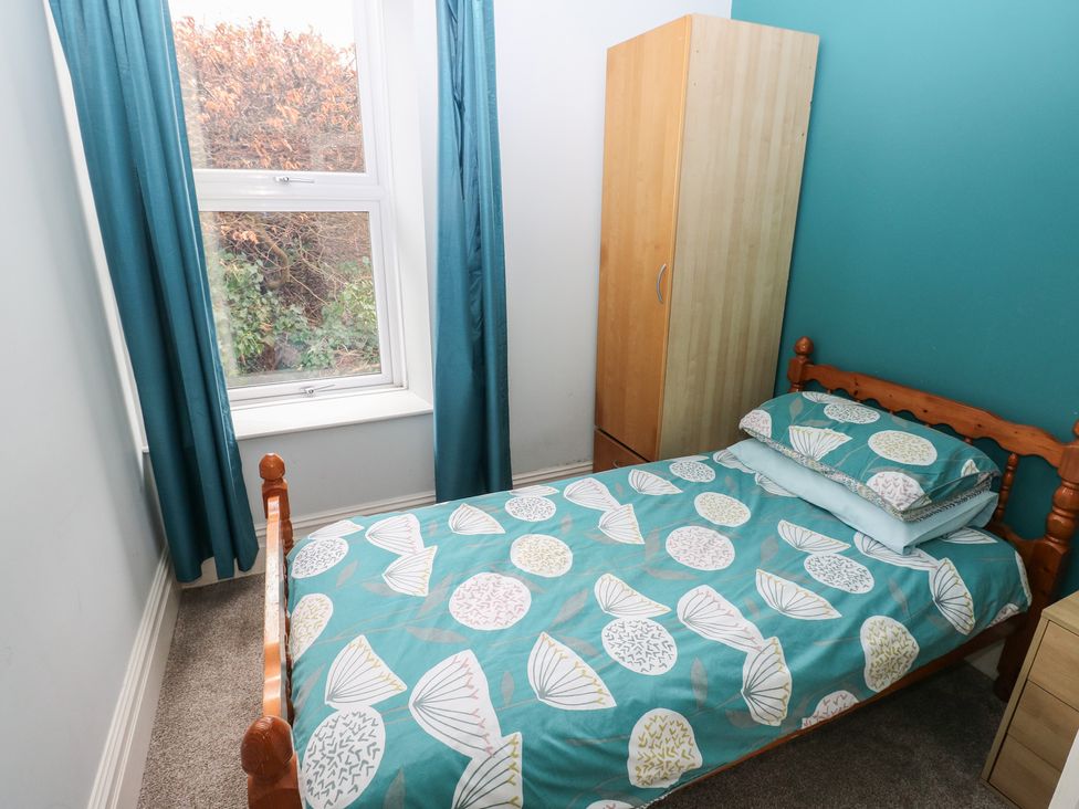 A bedroom with a single bed and wardrobe at Kenvor in Newport, Pembrokeshire