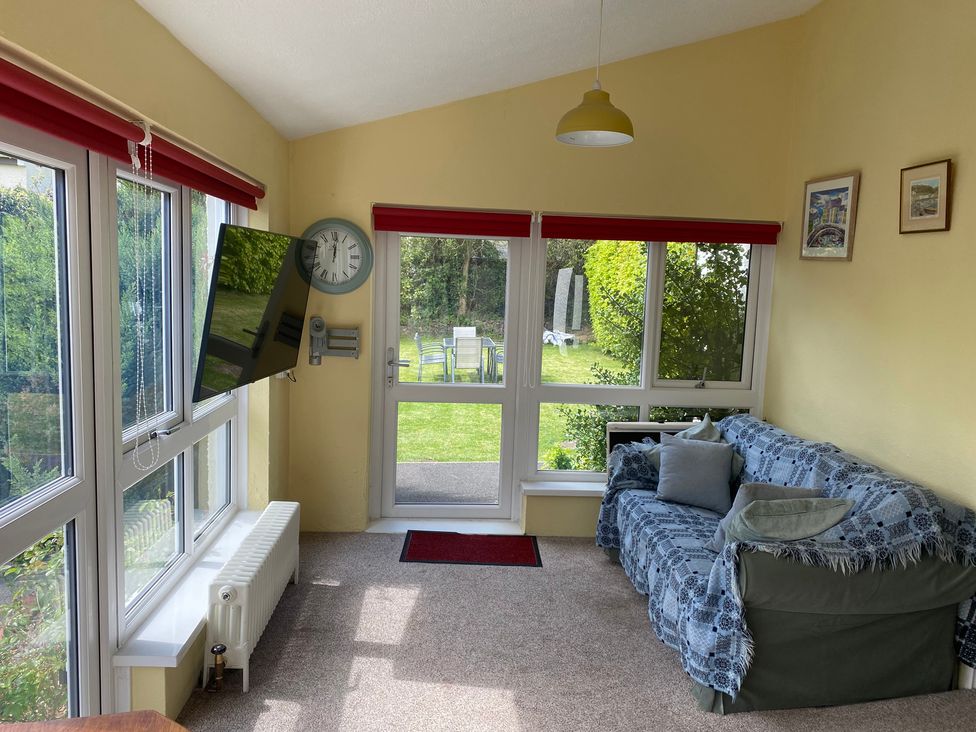 A snug with a television and clock at Kenvor in Newport, Pembrokeshire