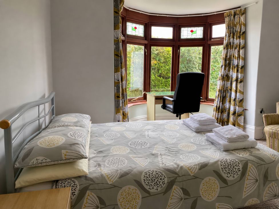 A bedroom with a bed and a chair at Kenvor in Newport, Pembrokeshire