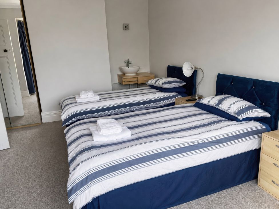 A bedroom with two single beds and a nightstand at Kenvor Newport, Pembrokeshire