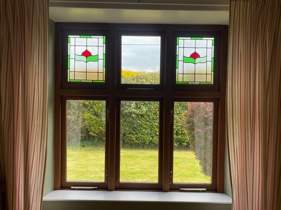 A window with stained glass and garden view at Kenvor Newport, Pembrokeshire