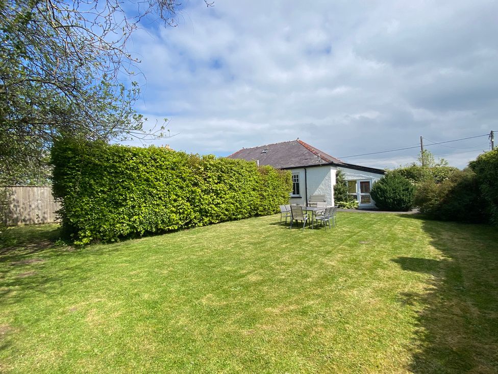 A garden with a house, table, and chairs at Kenvor in Newport, Pembrokeshire