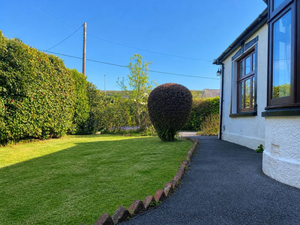A garden with a bush and a pathway at Kenvor in Newport, Pembrokeshire