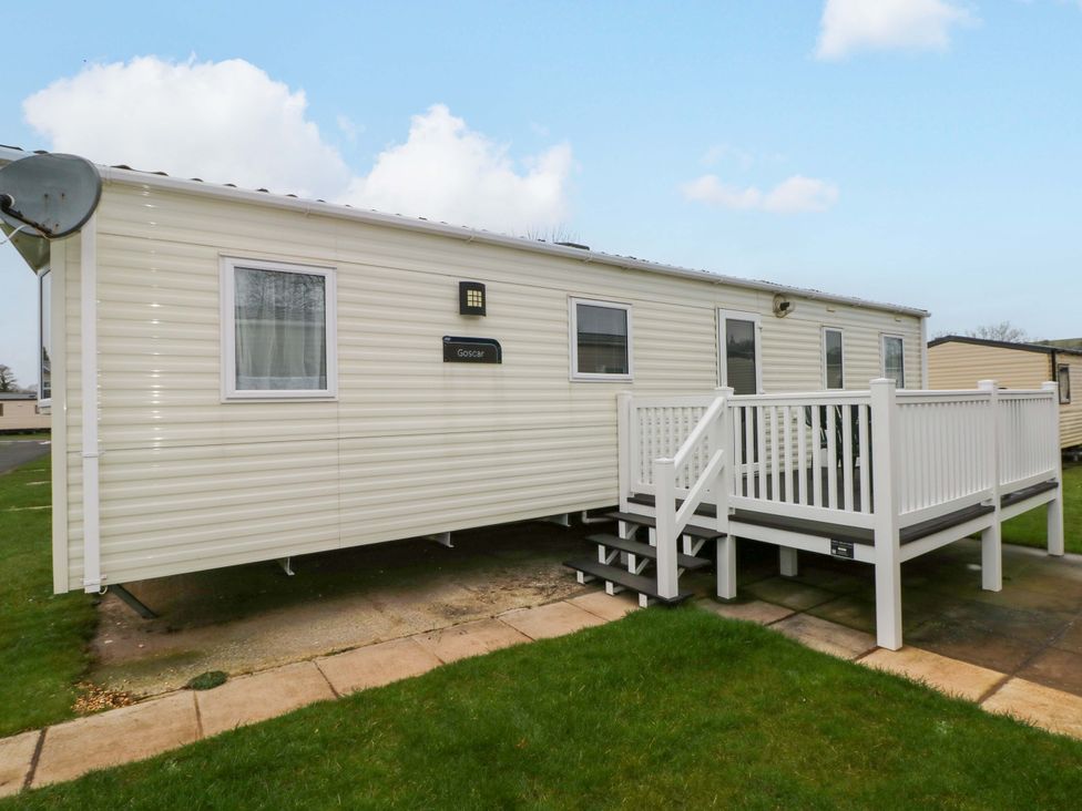 A mobile home with a deck and steps at 82 Manorbier Park in Manorbier