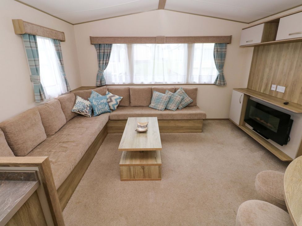 A living room with a sofa and coffee table at 82 Manorbier Park in Manorbier
