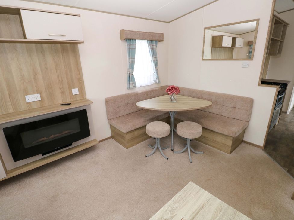 A dining area with a table and chairs at 82 Manorbier Park, Manorbier
