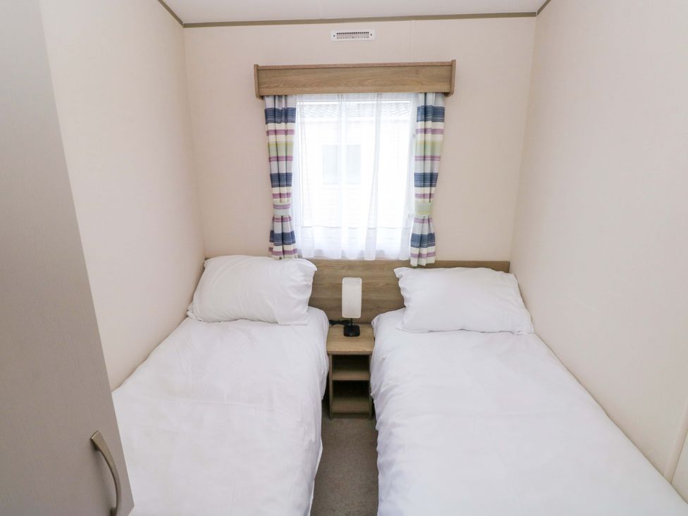 A bedroom with two single beds and a nightstand at 82 Manorbier Park in Manorbier