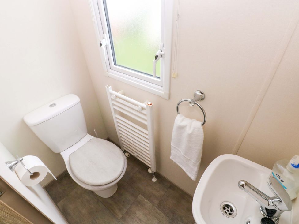 A bathroom with a toilet and hand basin at 82 Manorbier Park in Manorbier
