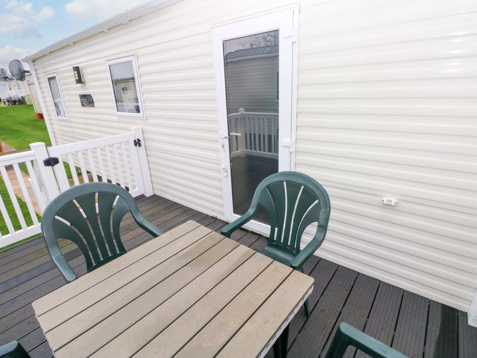 A deck area with a table and chairs at 82 Manorbier Park, Manorbier