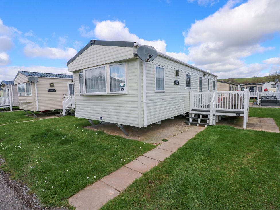 A caravan exterior with a satellite dish and steps at 82 Manorbier Park in Manorbier
