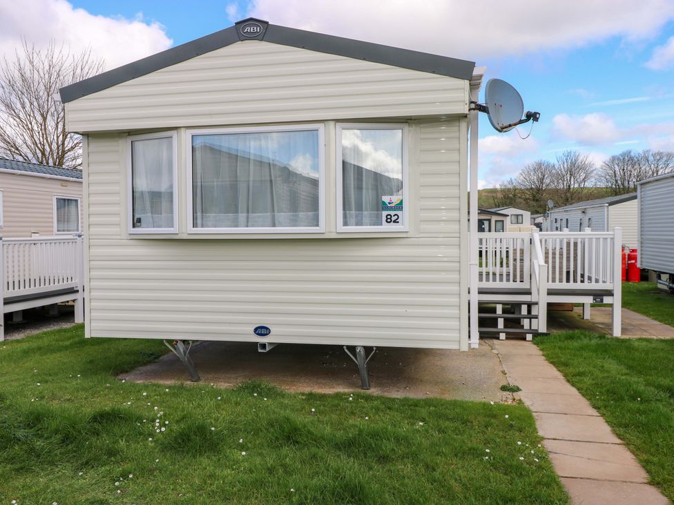 An outdoor view of a mobile home with a satellite dish at 82 Manorbier Park in Manorbier