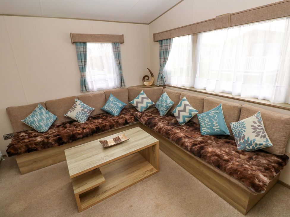 A living room with a sofa and coffee table at 82 Manorbier Park in Manorbier