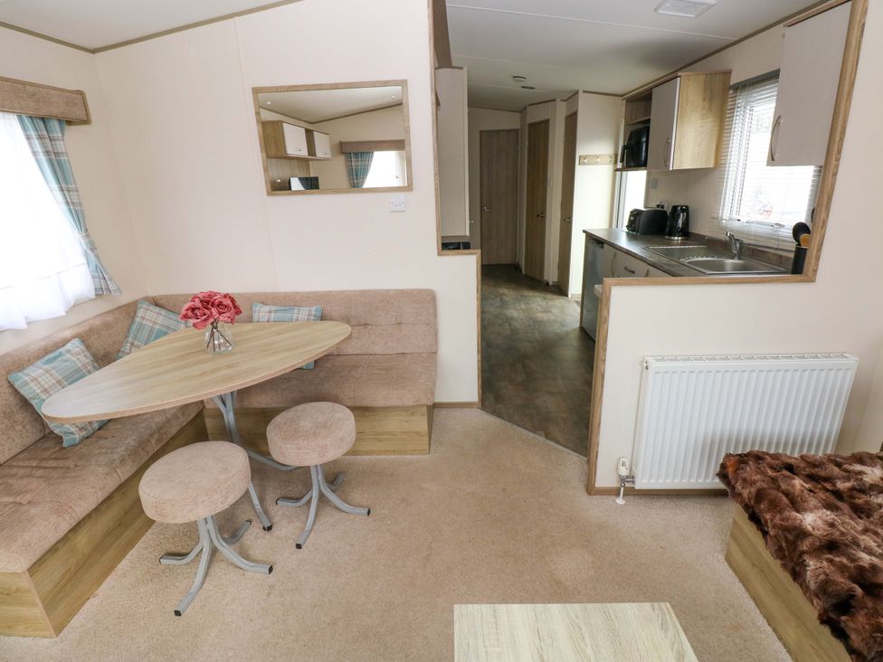 A living room with a table and sofa at 82 Manorbier Park in Manorbier
