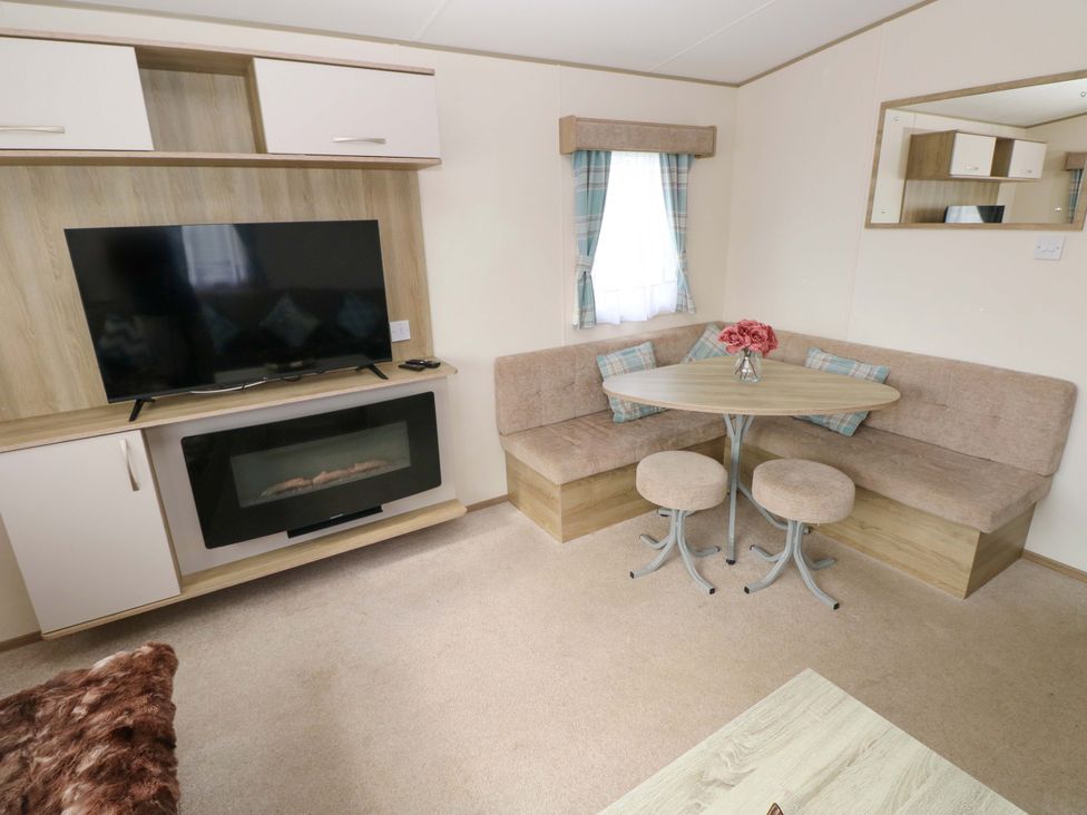 A living room with a TV and sofa at 82 Manorbier Park in Manorbier