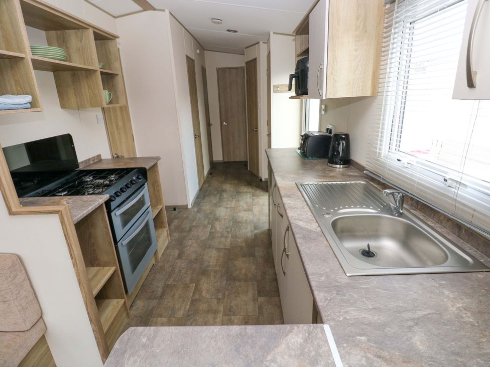 A kitchen with cabinets and appliances at 82 Manorbier Park in Manorbier