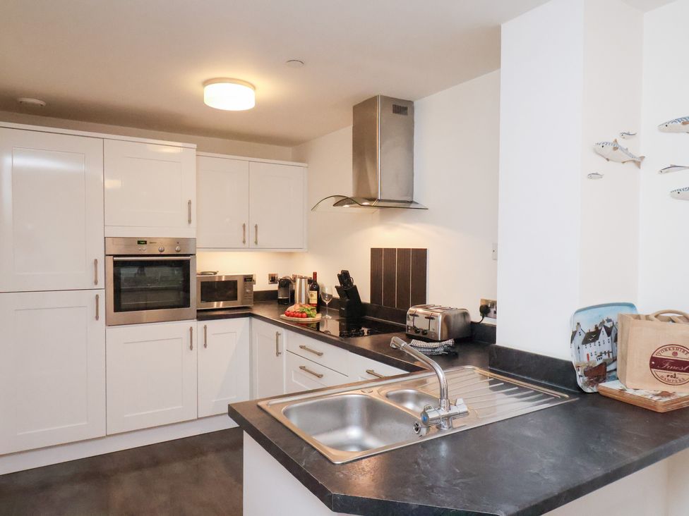 A kitchen with a sink and appliances at One Union Mill - garden apartment in Whitby