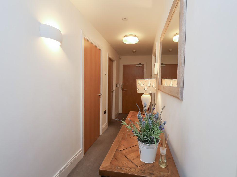 A hallway with a plant on a table at One Union Mill - garden apartment in Whitby