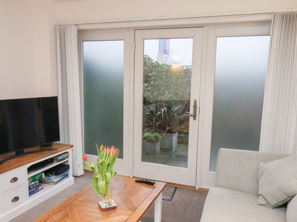 A living room with a television and a coffee table at One Union Mill - garden apartment in Whitby