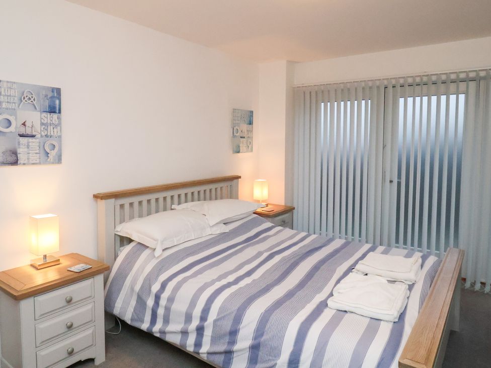 A bedroom with a bed and nightstands at One Union Mill - garden apartment in Whitby