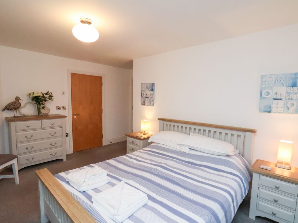 A bedroom with a bed, bedside table, and chest of drawers at One Union Mill - garden apartment in Whitby