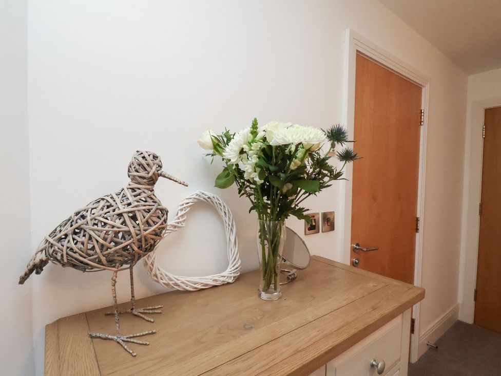 A decorative arrangement with a bird and flowers in an entryway at One Union Mill - garden apartment in Whitby