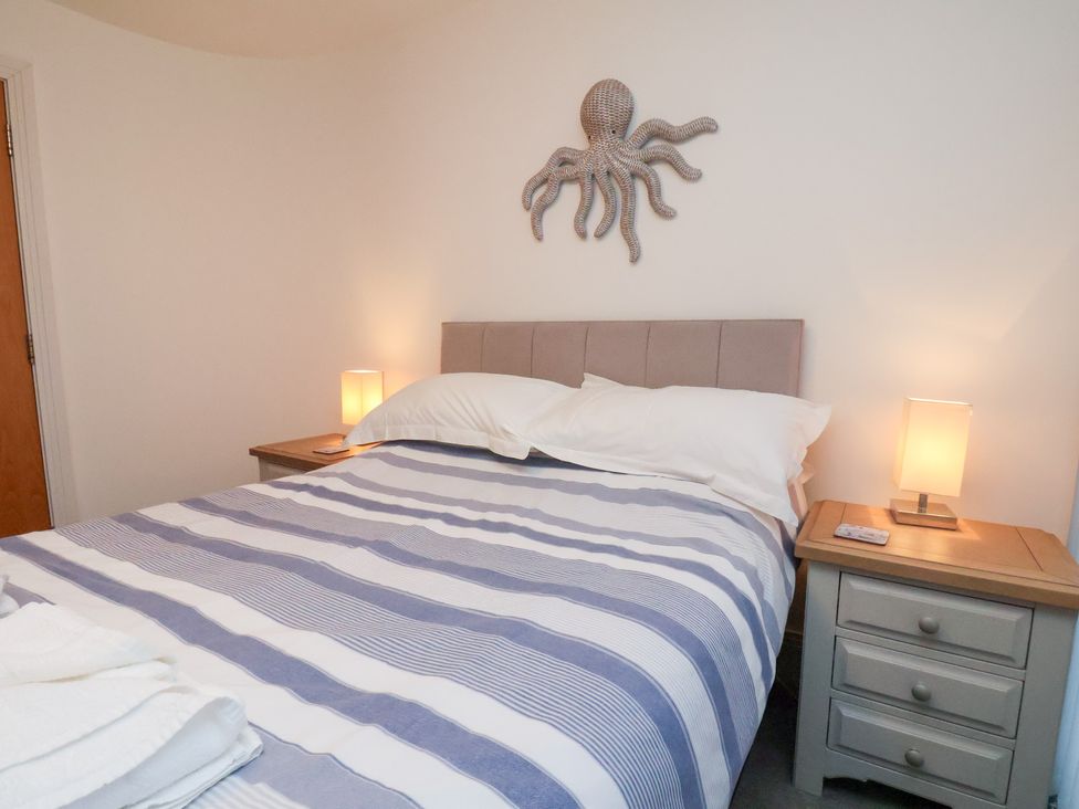 A bedroom with a bed and bedside tables at One Union Mill - garden apartment Whitby