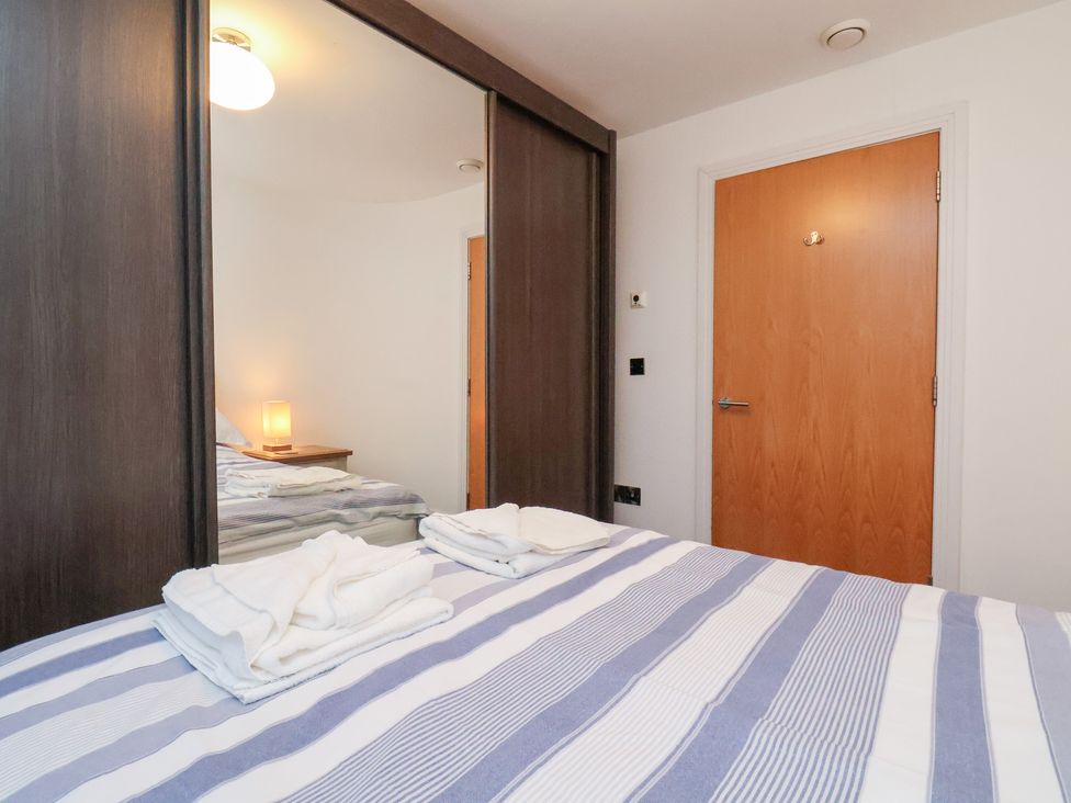 A bedroom with a bed and wardrobe at One Union Mill - garden apartment in Whitby