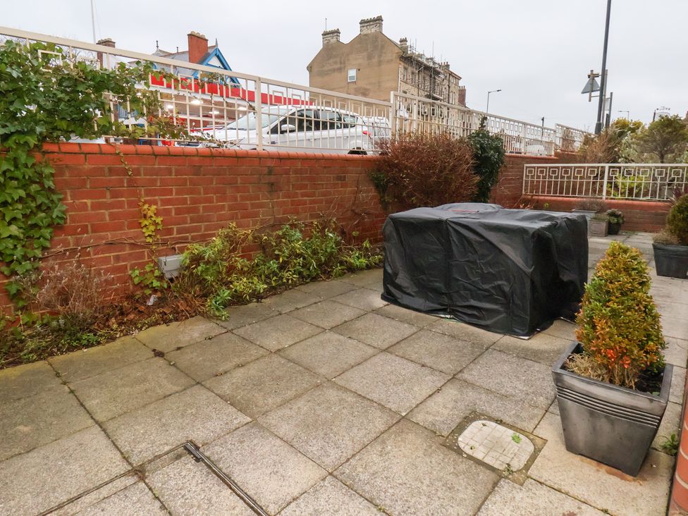 A garden with a paved area and potted plants at One Union Mill - garden apartment in Whitby
