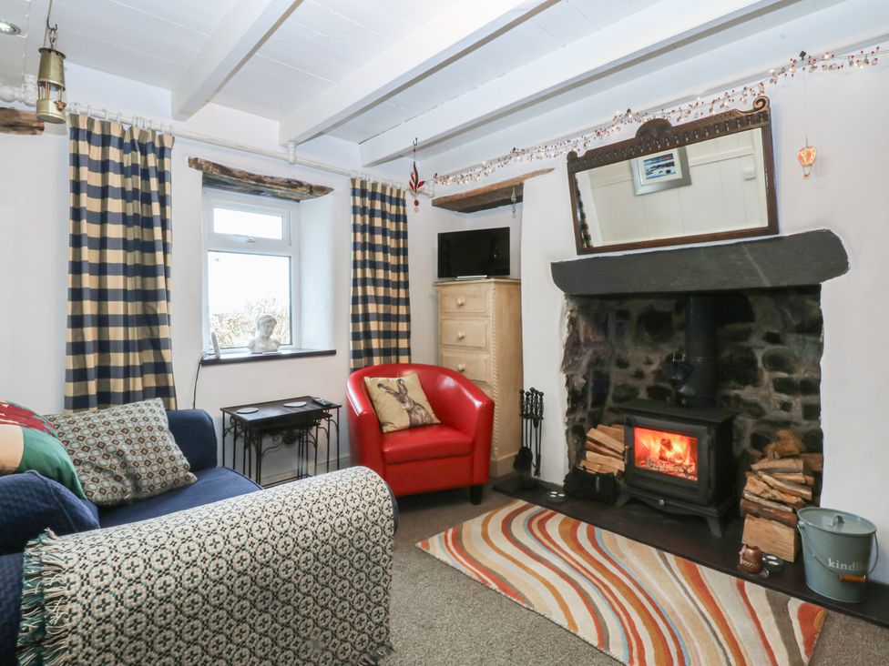 A living room with a fireplace and sofa at Parc y Brenin Holidays, Abersoch