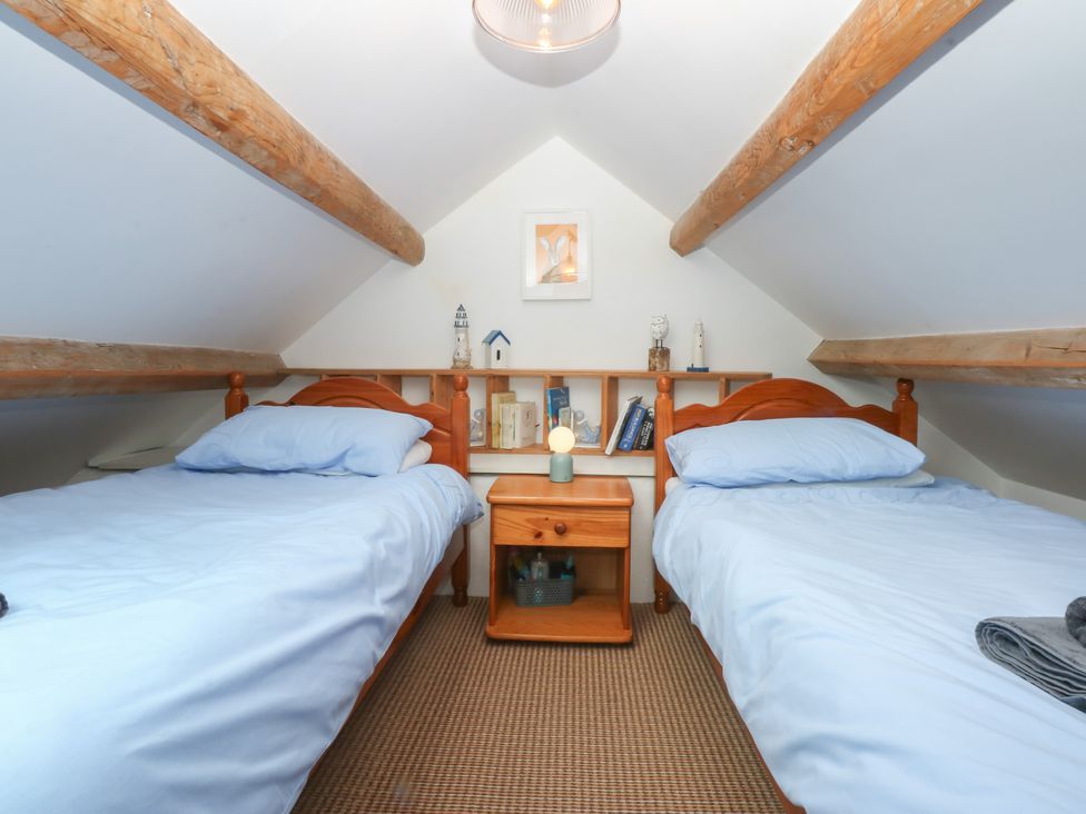 A bedroom with two beds and a nightstand at Parc y Brenin Holidays, Abersoch