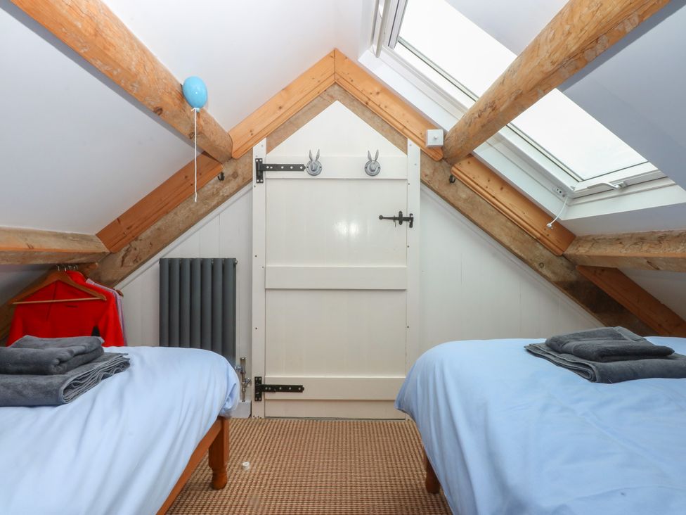 A bedroom with two beds and a door at Parc y Brenin Holidays, Abersoch