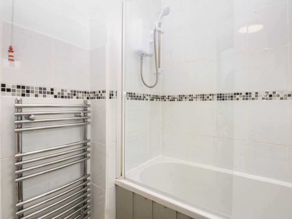 A bathroom with a bathtub and shower at Parc y Brenin Holidays, Abersoch