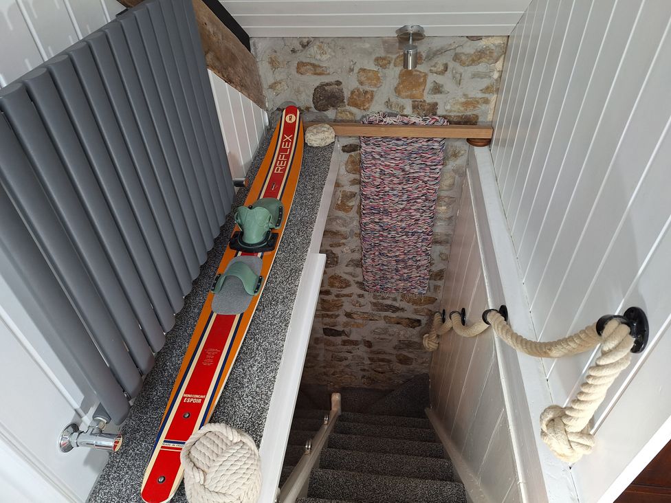 A staircase with skis and a radiator at Parc y Brenin Holidays, Cilan near Abersoch