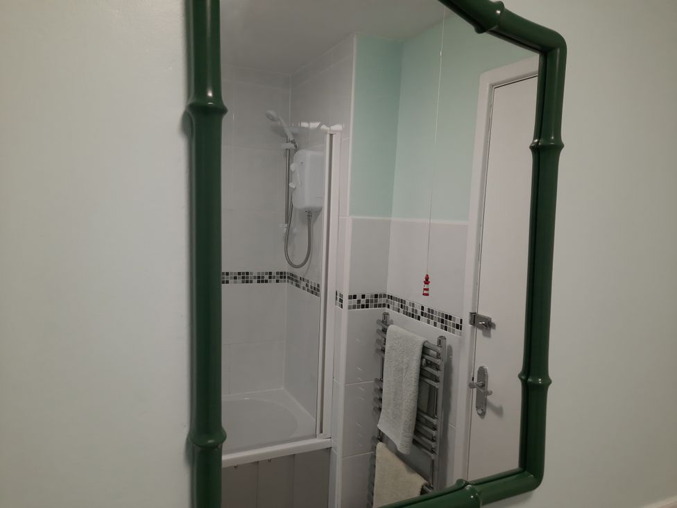 A bathroom with a shower and towel rack at Parc y Brenin Holidays, Cilan near Abersoch