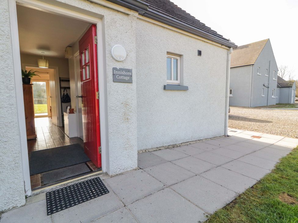 An entrance area with a red door and pathway at Innishore Cottage