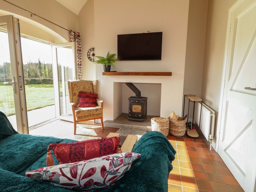 A living room with a tv and stove at Innishore Cottage