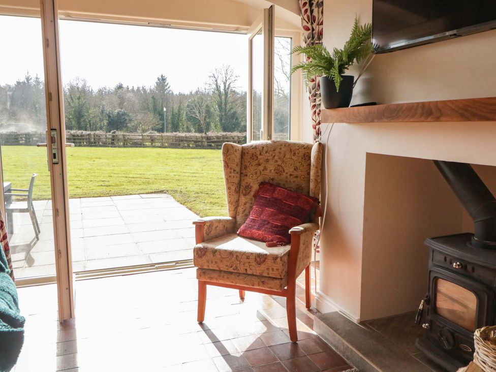A living room with an armchair and a television at Innishore Cottage
