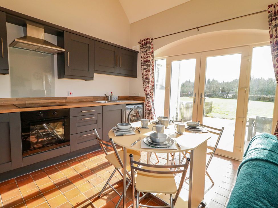 A kitchen with a dining table and chairs at Innishore Cottage