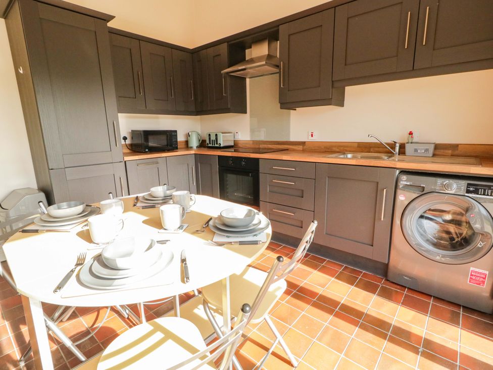 A kitchen with cabinets and appliances at Innishore Cottage