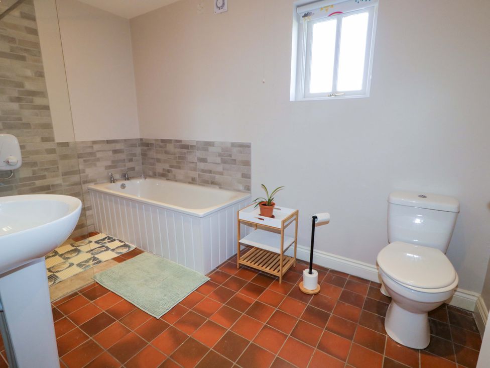 A bathroom with a bathtub and sink at Innishore Cottage