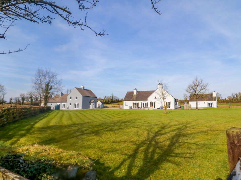 A view of multiple houses and green grass at Innishore Cottage in 