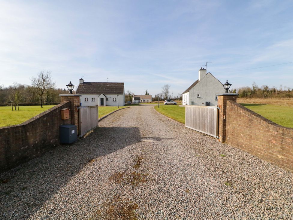 A gravel driveway leading to houses with a gate at Innishore Cottage 