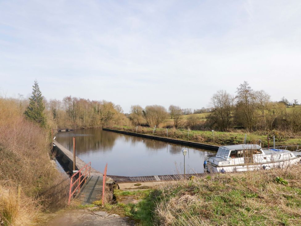 A dock with a boat on water at Innishore Cottage in 