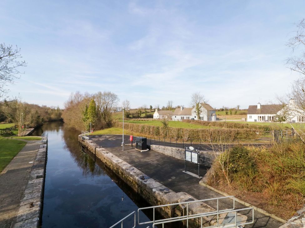 A canal with houses and trees in the background at Innishore Cottage